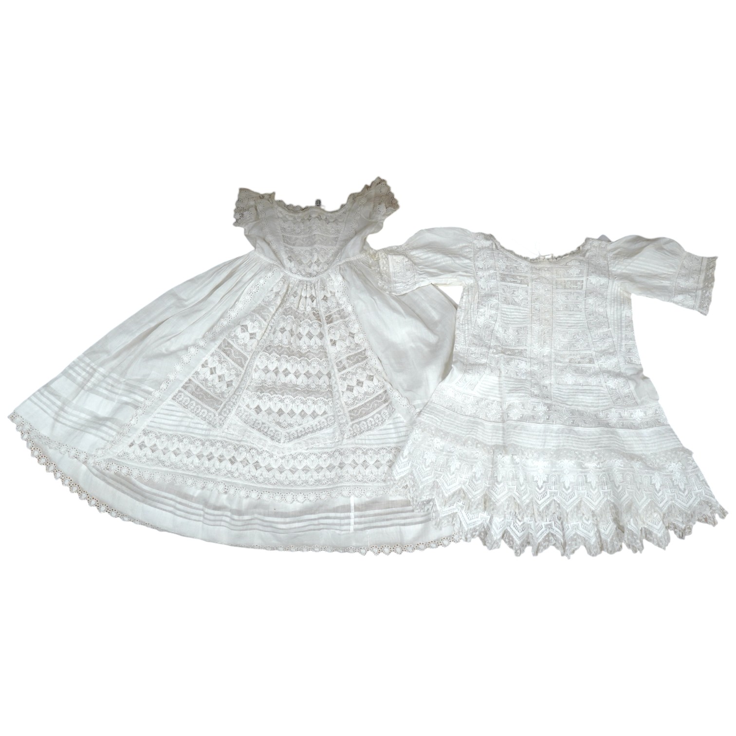 Two unusual 19th century intricately white worked children’s dresses, one hand worked with fine panels of white work, feather stitching and tucking, edged and inserted with hand made Valenciennes lace, the other worked i